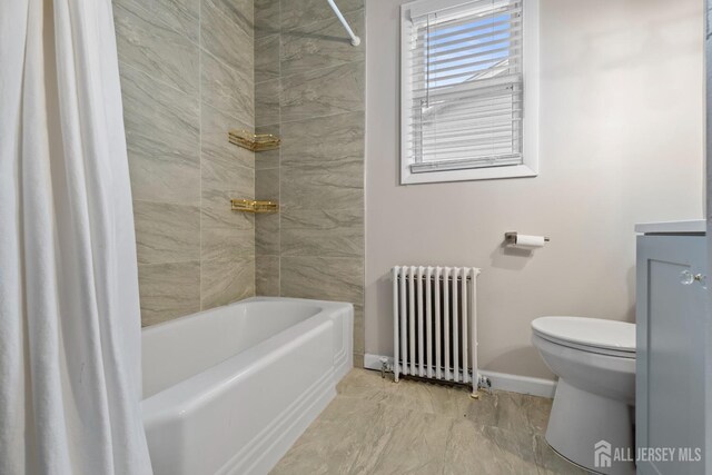 bathroom featuring tiled shower / bath combo, toilet, and radiator heating unit