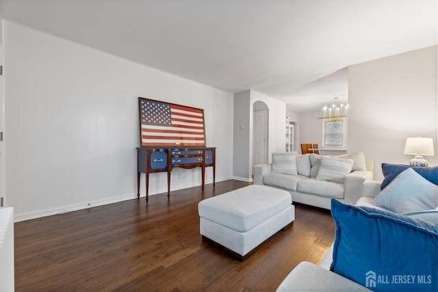 living room with a notable chandelier and dark wood-type flooring