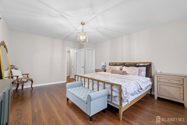 bedroom with dark hardwood / wood-style flooring and a chandelier