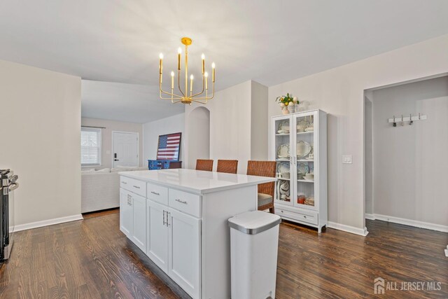 kitchen with a center island, decorative light fixtures, a notable chandelier, dark hardwood / wood-style flooring, and white cabinetry