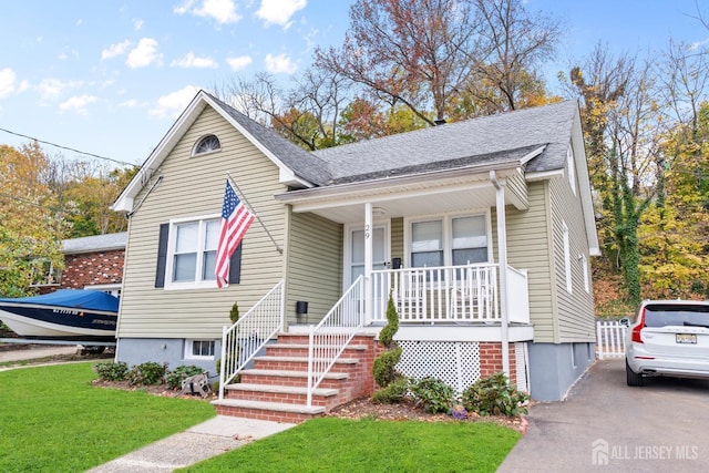 bungalow with covered porch and a front yard