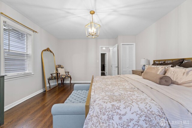 bedroom with a chandelier, a closet, and dark wood-type flooring