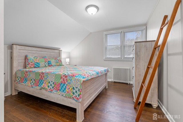 bedroom with lofted ceiling, dark wood-type flooring, and radiator