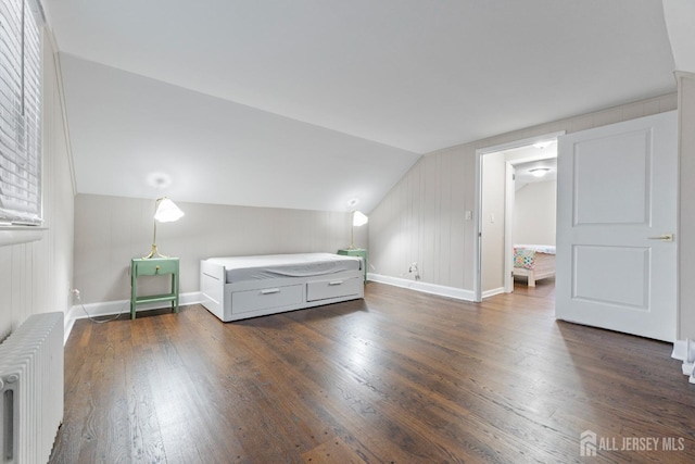 unfurnished bedroom featuring lofted ceiling, dark wood-type flooring, and radiator