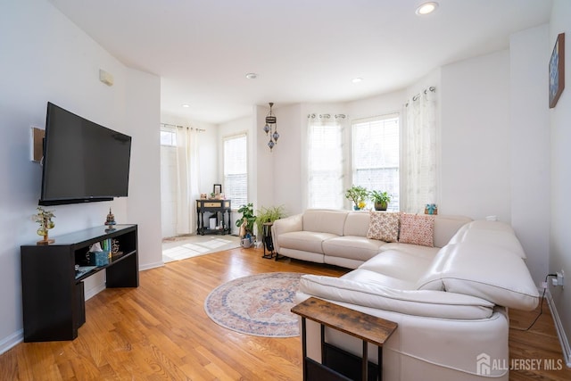 living room featuring recessed lighting, light wood-style floors, and baseboards