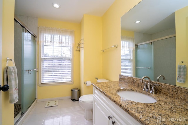 bathroom with a shower stall, toilet, and baseboards