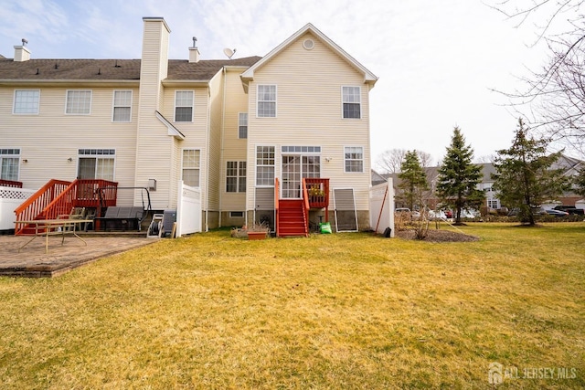 rear view of property with a yard, a patio, and a chimney