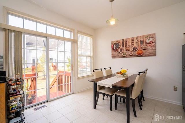 dining space with light tile patterned flooring, baseboards, and visible vents