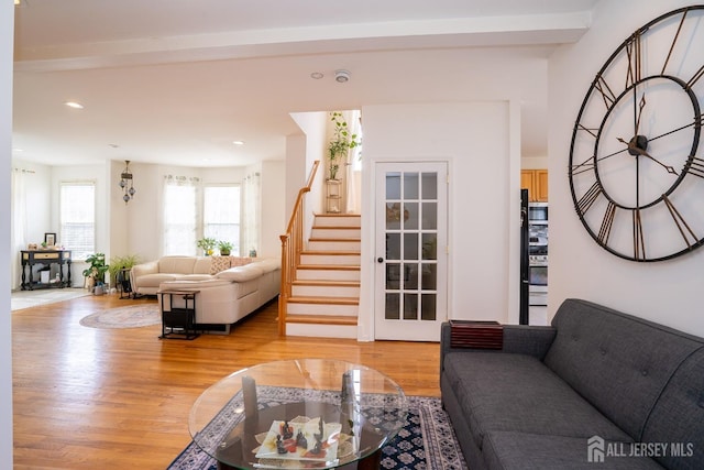 living area featuring recessed lighting, light wood-style flooring, stairs, and beamed ceiling