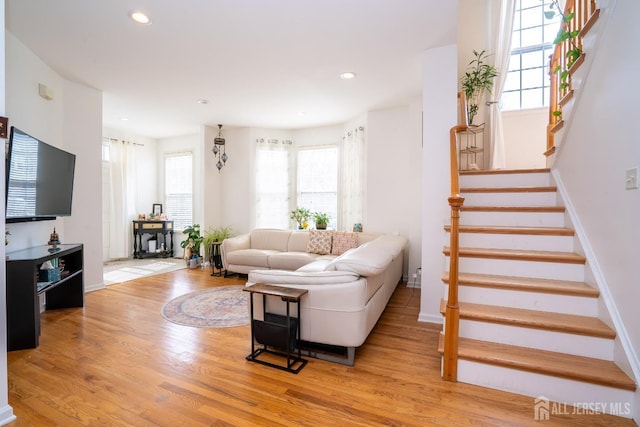 living room with stairway, recessed lighting, light wood-style floors, and baseboards