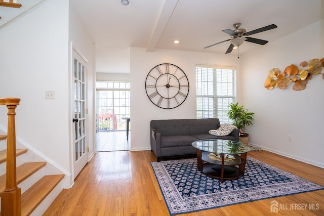 living area with a wealth of natural light, beam ceiling, and wood finished floors