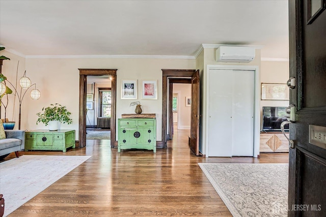 227 Lawrence Ave, Highland Park, NJ 08904 - living area featuring a wall mounted air conditioner, radiator heating unit, ornamental molding, and wood finished floors