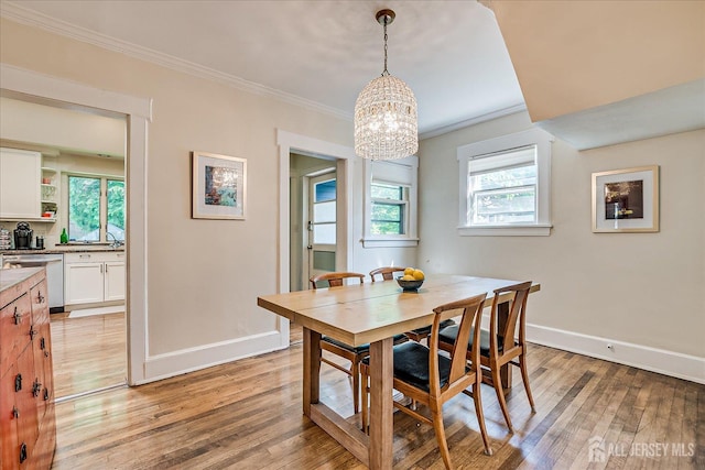 227 Lawrence Ave, Highland Park, NJ 08904 - dining area featuring a chandelier, crown molding, and light wood-style flooring