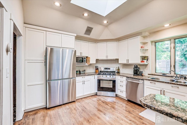 227 Lawrence Ave, Highland Park, NJ 08904 - kitchen featuring stainless steel appliances, white cabinets, dark stone counters, a skylight, and recessed lighting
