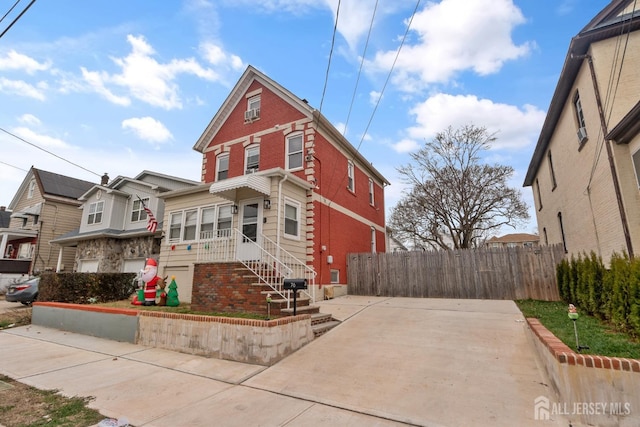 view of front of house with fence and brick siding