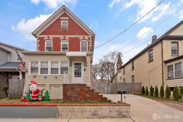 view of front of home featuring crawl space, driveway, fence, and brick siding