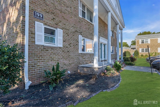 view of home's exterior featuring a yard and brick siding