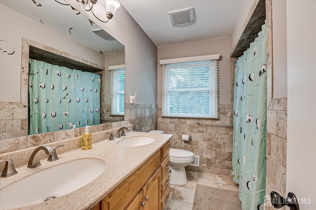 8 Renee Ct, Edison, NJ 08820 - full bathroom with tile walls, toilet, stone tile flooring, double vanity, and wainscoting