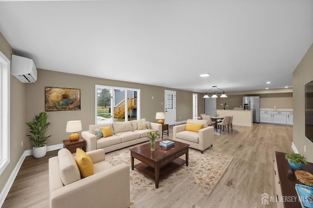 living room with an AC wall unit, light wood finished floors, recessed lighting, and baseboards