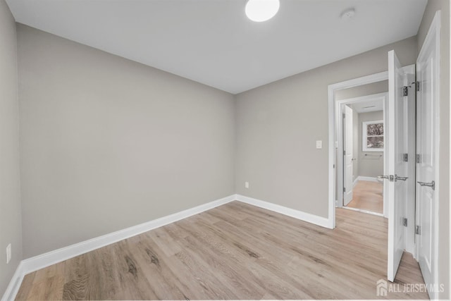 empty room with light wood finished floors and baseboards