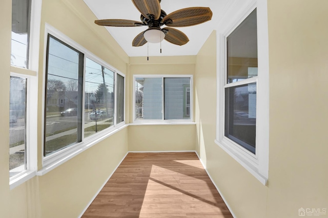 unfurnished sunroom with ceiling fan