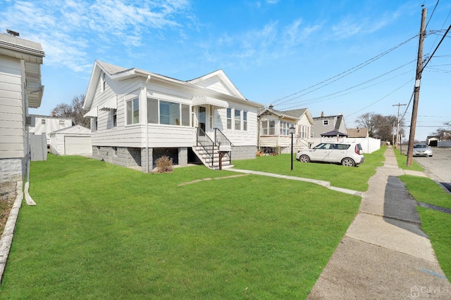 view of front of house featuring a front lawn and an outbuilding