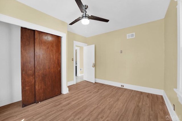 unfurnished bedroom with ceiling fan, a closet, and light wood-type flooring