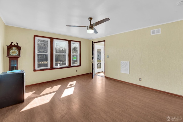 empty room featuring ceiling fan, ornamental molding, and hardwood / wood-style floors