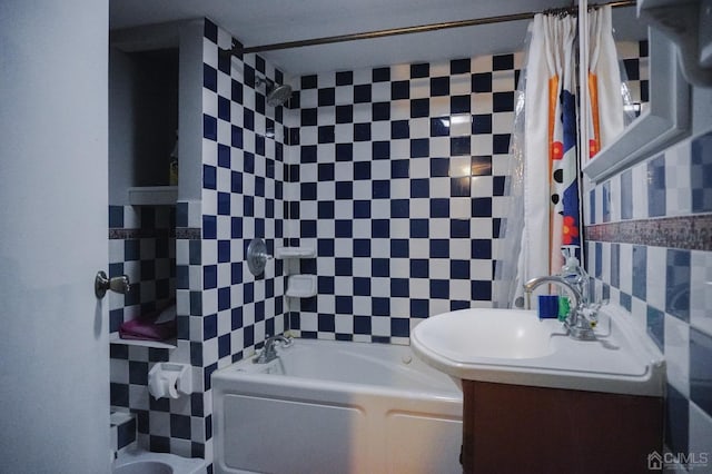 bathroom featuring vanity, shower / bath combination with curtain, and tile walls