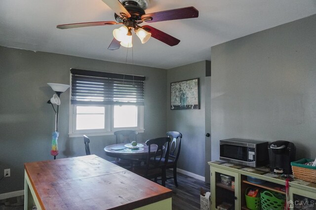 dining room featuring ceiling fan and dark wood-type flooring