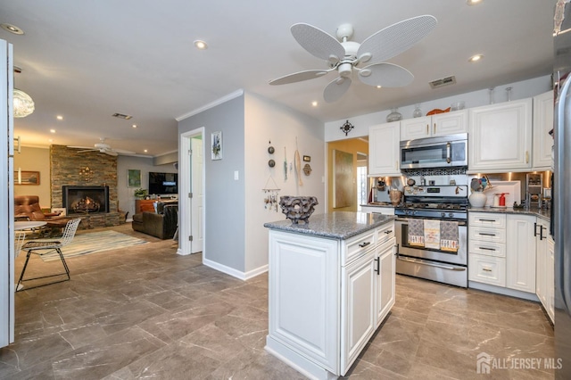 111 E Shrewsbury Dr E, Little Egg Harbor, NJ 08087 - kitchen with appliances with stainless steel finishes, a ceiling fan, a center island, white cabinets, and ornamental molding