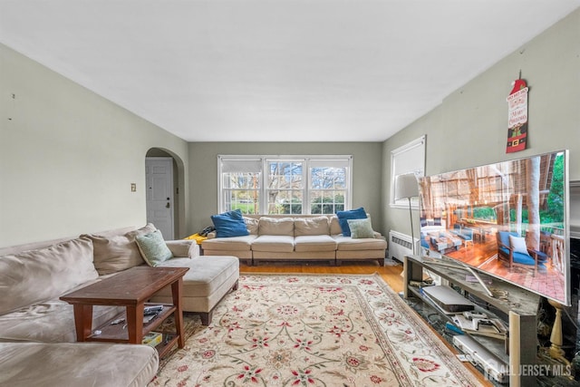 286 Easton Ave, New Brunswick, NJ 08901 - living area featuring radiator, arched walkways, and wood finished floors