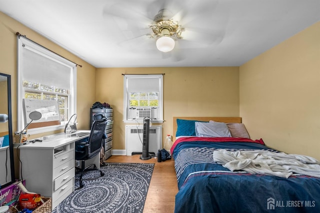 286 Easton Ave, New Brunswick, NJ 08901 - bedroom featuring radiator, an office area, wood finished floors, and a ceiling fan
