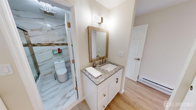 full bathroom with visible vents, toilet, a marble finish shower, baseboard heating, and vanity