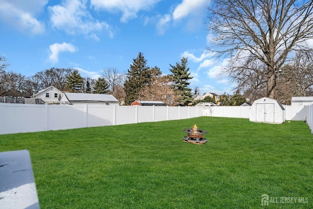 view of yard with a storage unit and an outdoor fire pit