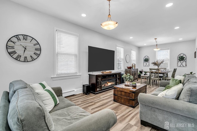 living room with light hardwood / wood-style floors and a baseboard heating unit