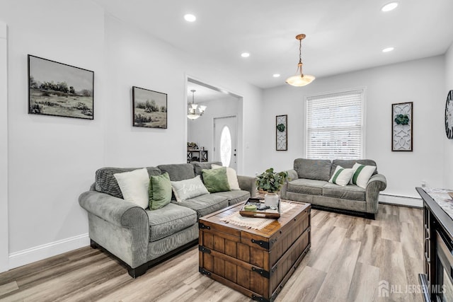 living room featuring a baseboard radiator and light hardwood / wood-style flooring