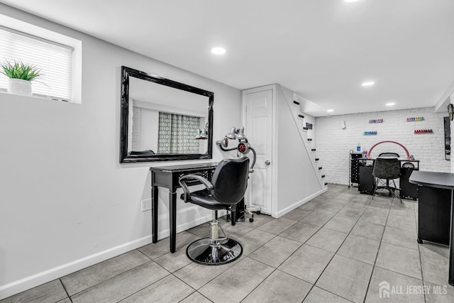 tiled office space featuring brick wall