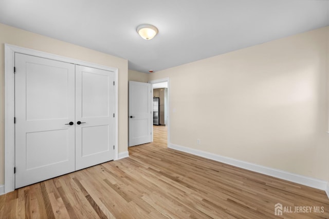 unfurnished bedroom with a closet and light hardwood / wood-style flooring