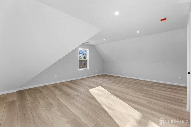 bonus room featuring light wood-type flooring and vaulted ceiling