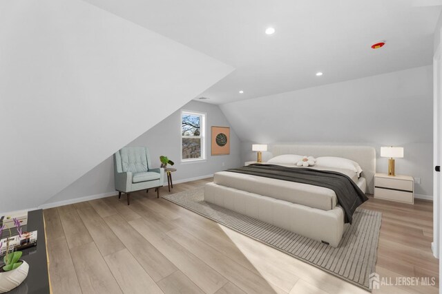 bedroom with light hardwood / wood-style floors and lofted ceiling