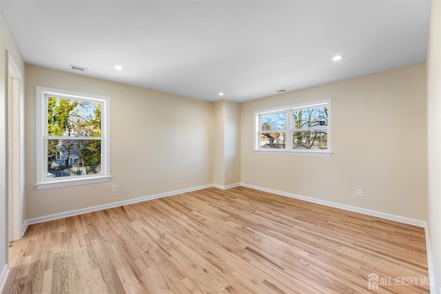 empty room featuring light hardwood / wood-style flooring and a wealth of natural light