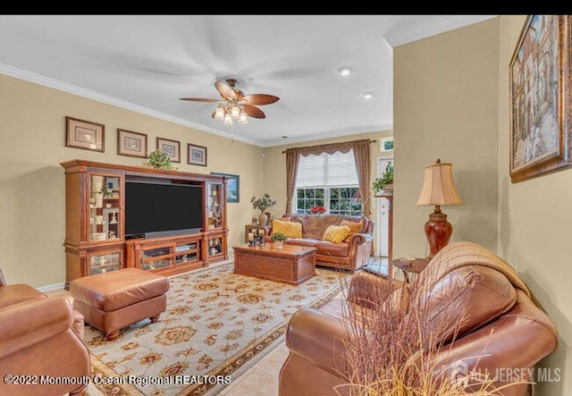 living area with ceiling fan, ornamental molding, baseboards, and tile patterned floors