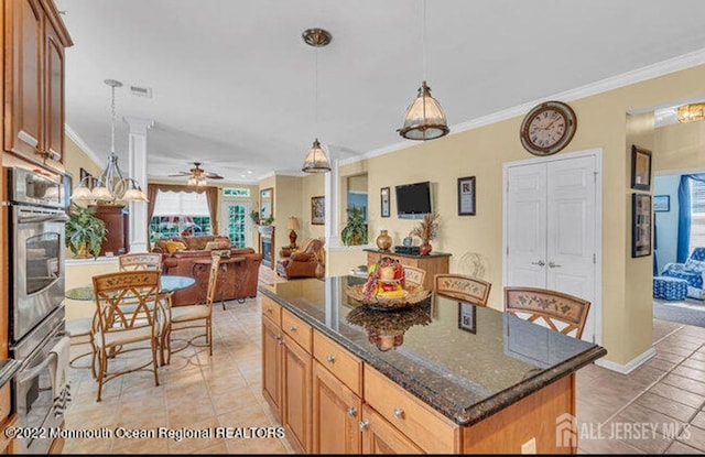 kitchen featuring crown molding, light tile patterned floors, visible vents, open floor plan, and stainless steel oven