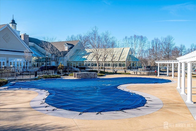 community pool featuring fence, a patio, and a pergola