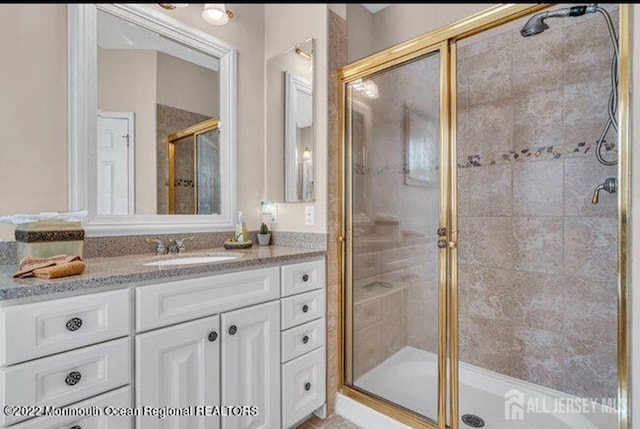 full bathroom with a shower stall and vanity