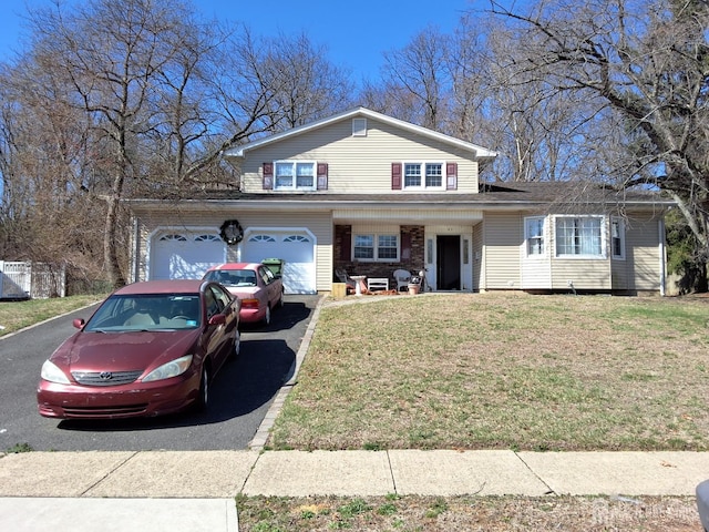 view of front facade with a front yard and aphalt driveway