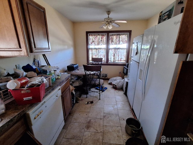 kitchen featuring dark countertops, white appliances, and ceiling fan