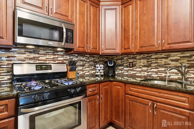 179 Sunshine Dr, Piscataway, NJ 08854 - kitchen with stainless steel appliances, backsplash, dark stone countertops, and brown cabinetry