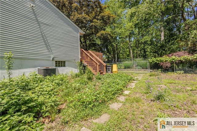 3 Revock Rd, East Brunswick, NJ 08816 - view of yard with central AC, stairs, and view of wooded area